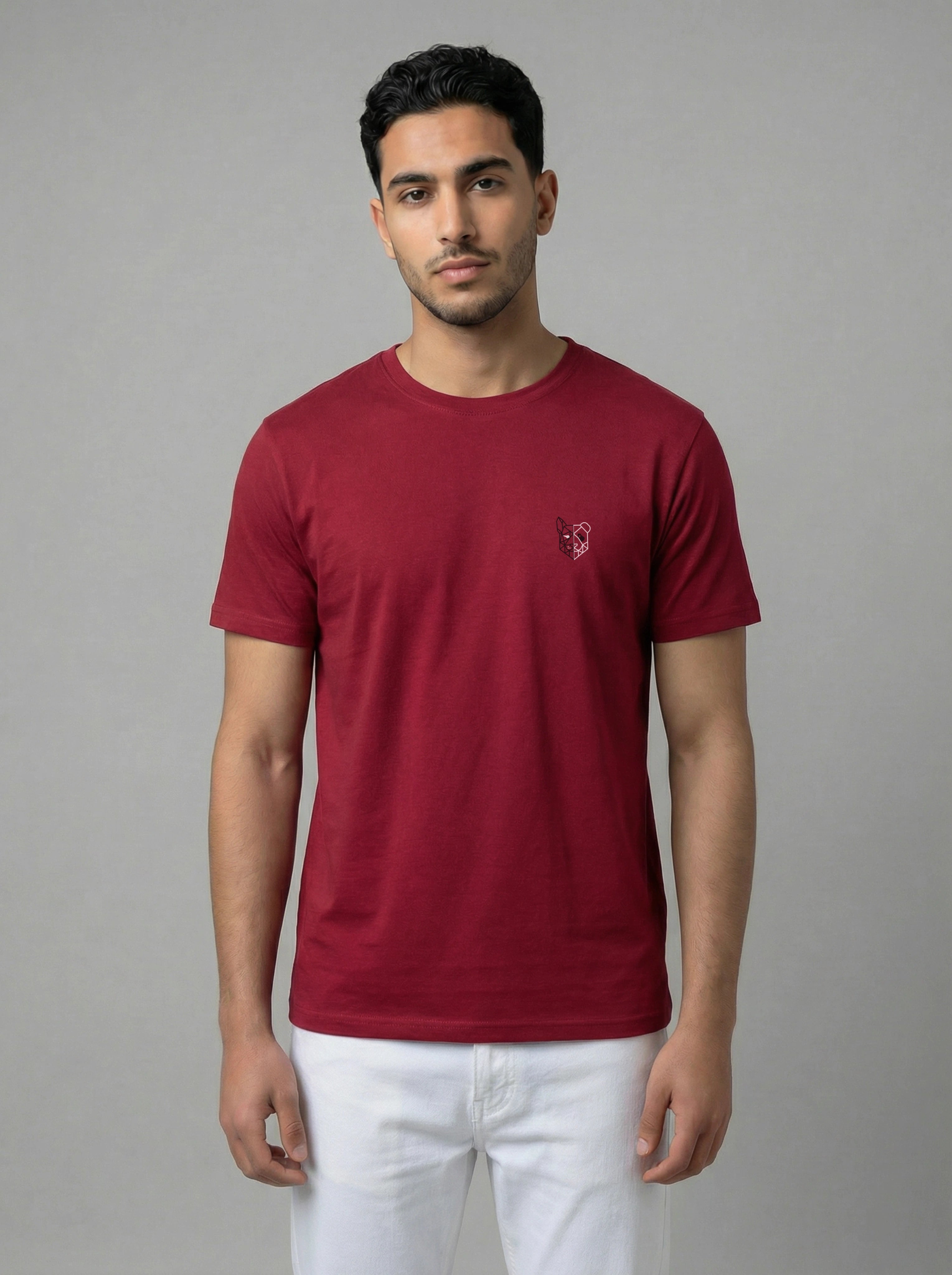 Man wearing a burgundy t-shirt with a small logo on a gray background