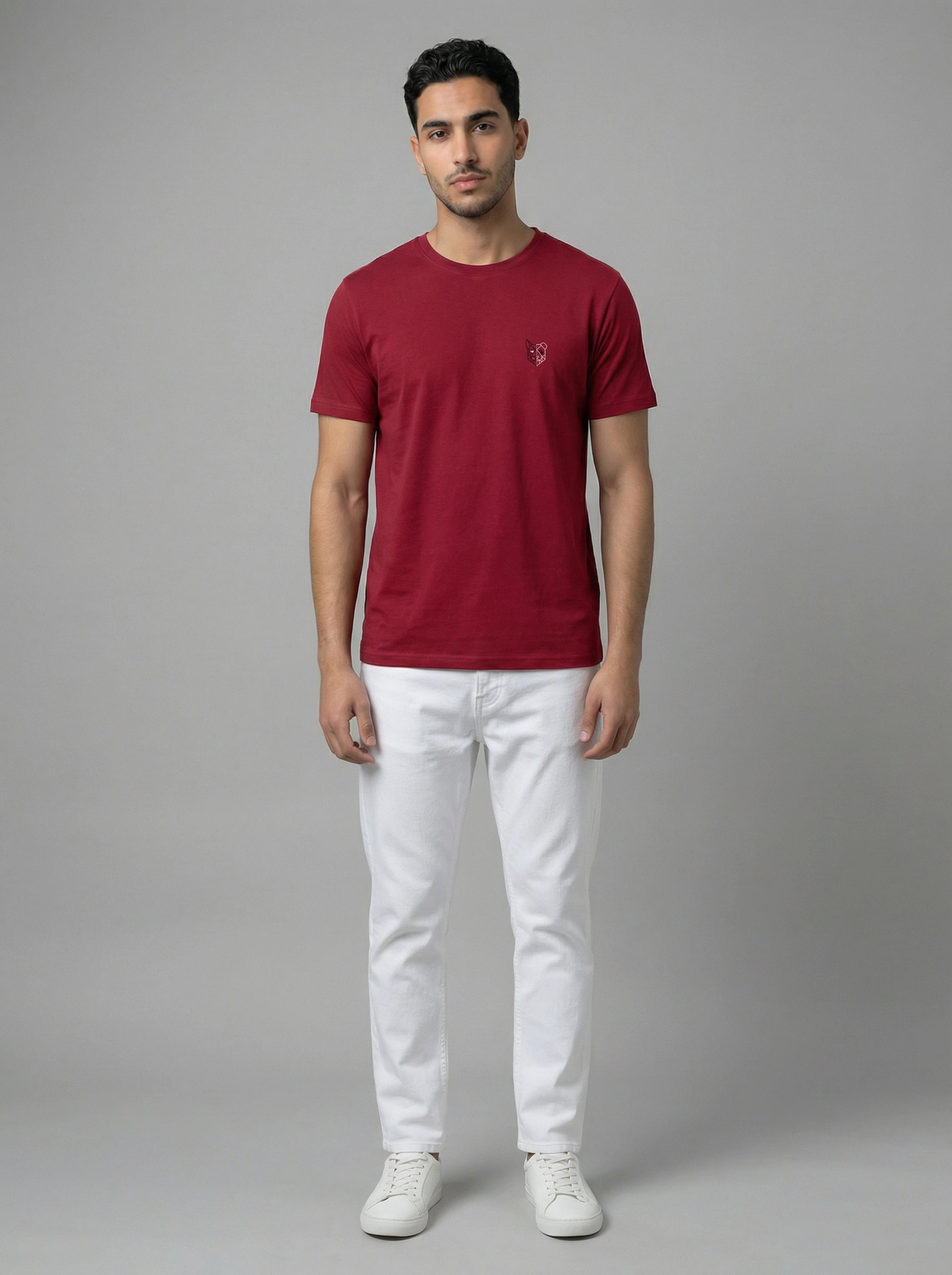 Man wearing a burgundy t-shirt and white pants on a gray background