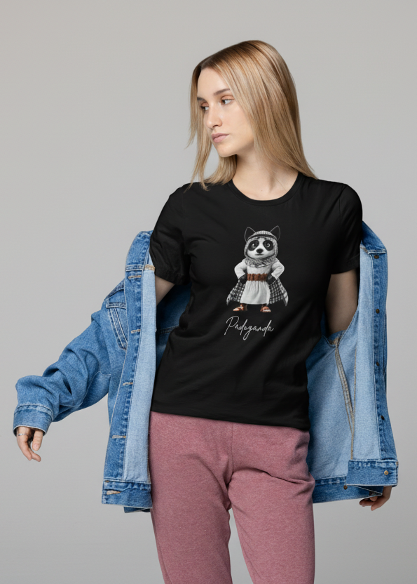 Woman wearing a black t-shirt with a graphic design and pink pants on a white background